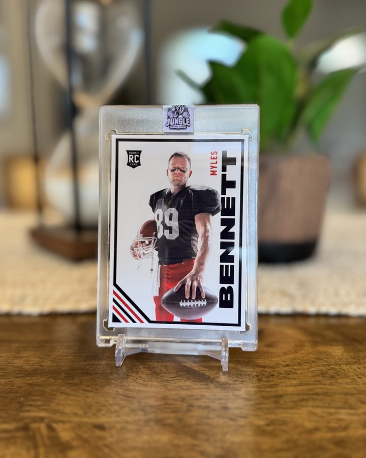 Front of a custom football card for Myles Bennett, sealed in a Jungle Sports Cards acrylic case and standing on a wooden table